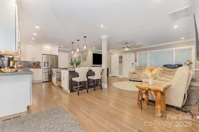 a living room with furniture and kitchen view