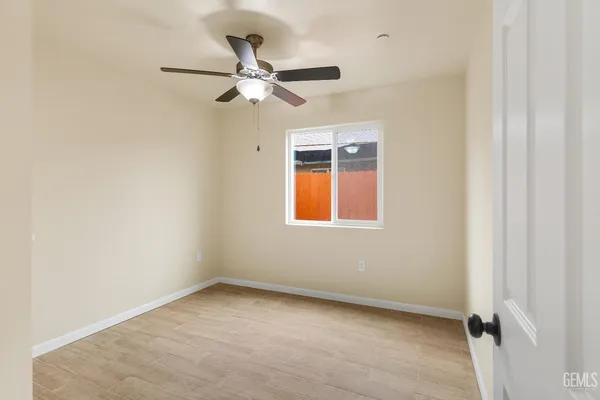 an empty room with a window and a fan
