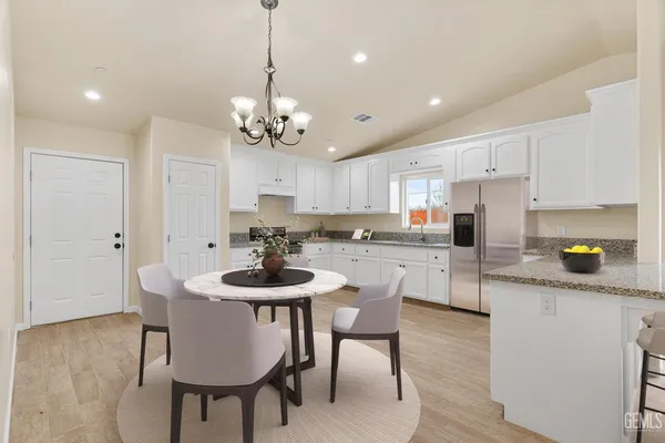 a kitchen with a dining table chairs stainless steel appliances and cabinets