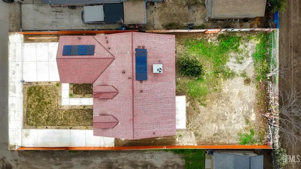 a aerial view of a house with a yard and large tree