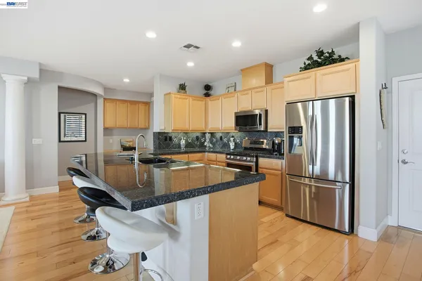 a large kitchen with a center island stainless steel appliances and a window