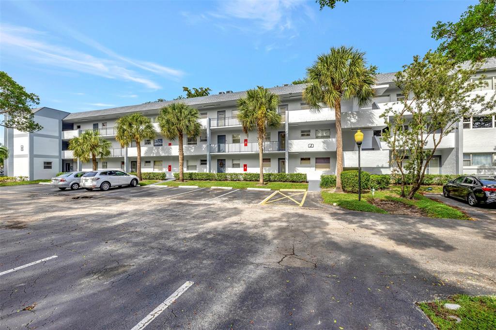 8380 Sands Point Boulevard, Unit J306 Tamarac, FL 33321 - Photo 11 of 33 a view of a parked cars in front of a building