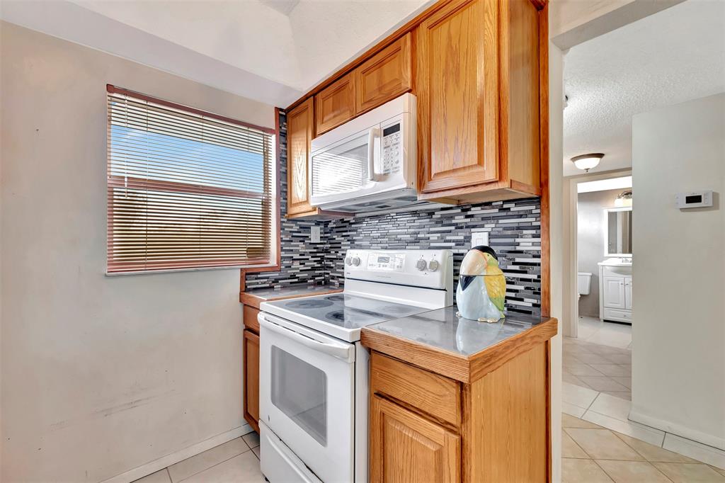 8380 Sands Point Boulevard, Unit J306 Tamarac, FL 33321 - Photo 17 of 33 a stove top oven sitting inside of a kitchen