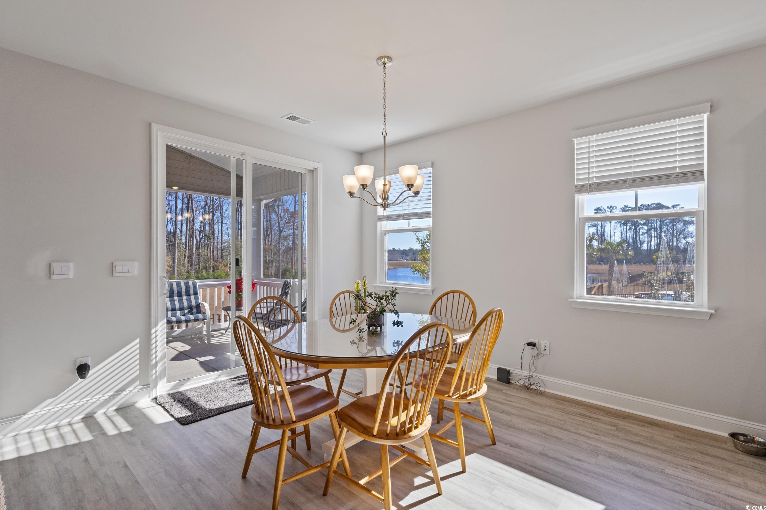 4070 Rutherford Court Little River, SC 29566 - Photo 12 of 40 Dining space featuring wood finished floors and a chandelier