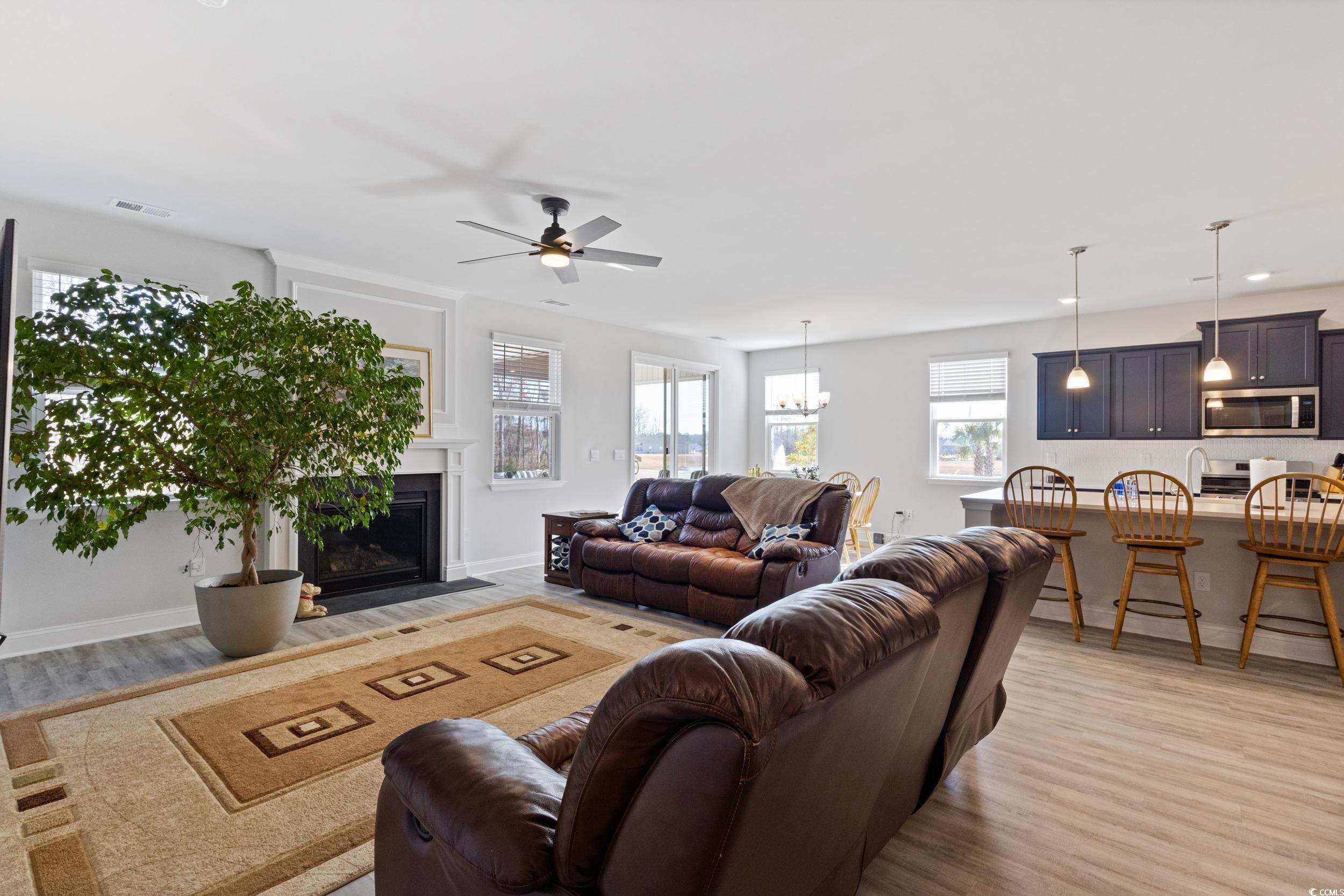4070 Rutherford Court Little River, SC 29566 - Photo 14 of 40 Living room with light wood-style floors, a fireplace with flush hearth, ceiling fan, and a chandelier
