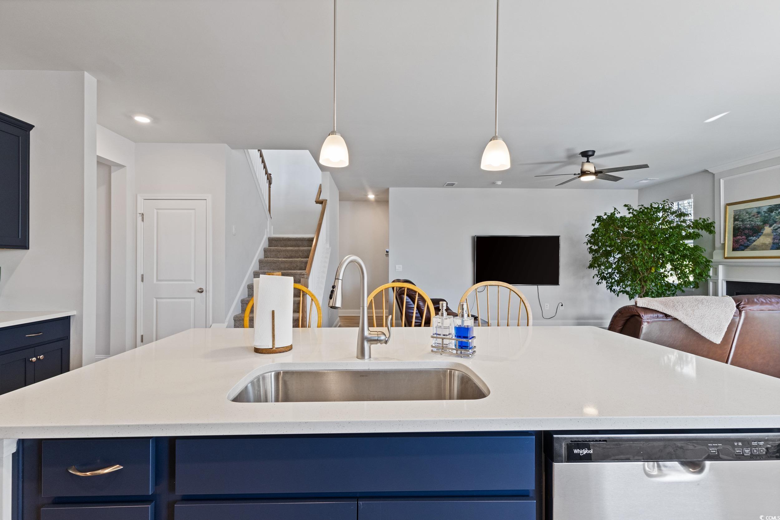4070 Rutherford Court Little River, SC 29566 - Photo 8 of 40 Kitchen featuring blue cabinets, dishwasher, hanging light fixtures, a kitchen island with sink, and light stone counters