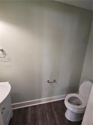 a white toilet sitting next to a wooden cabinet