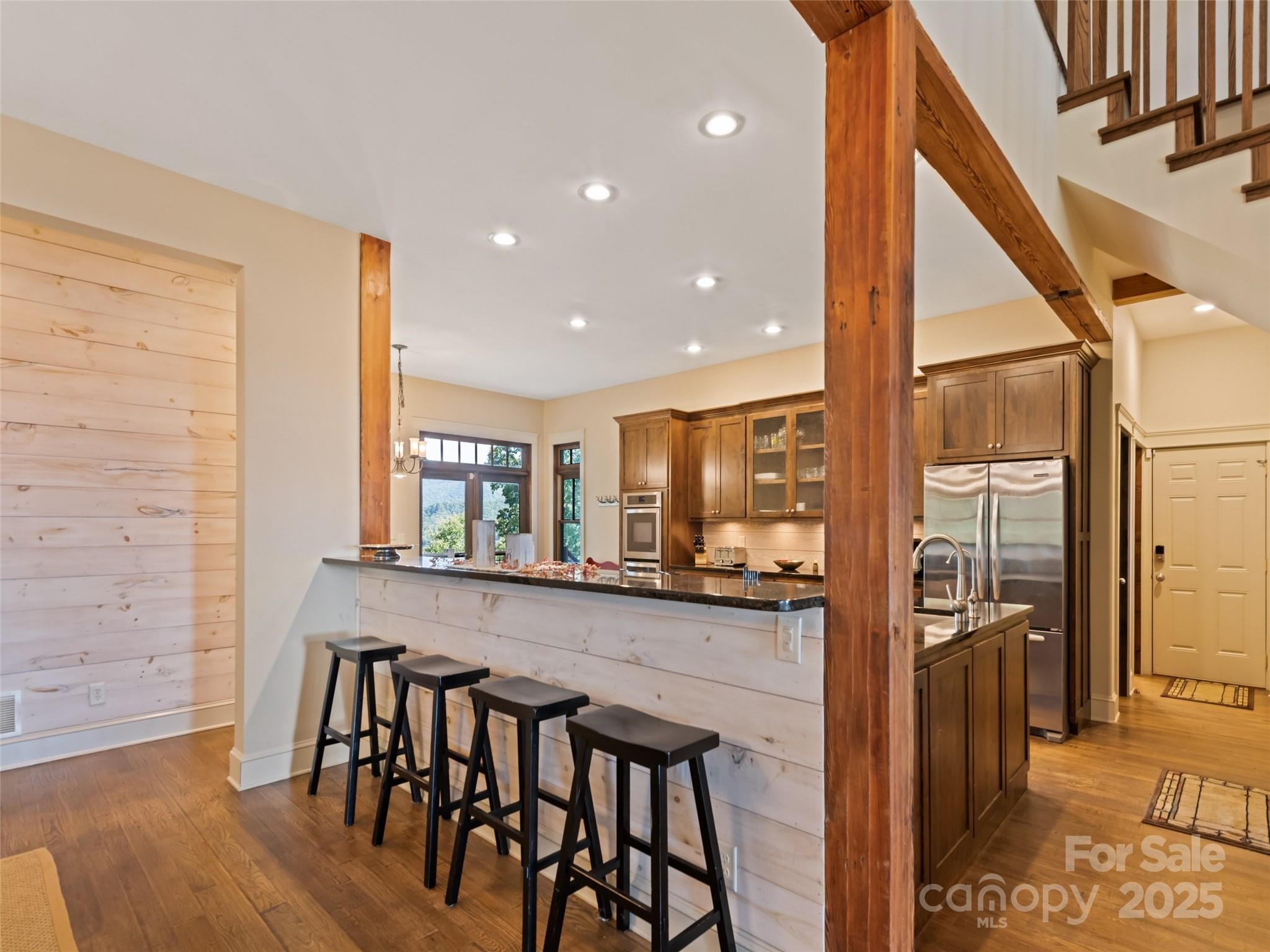 1635 Quest Ridge Sylva, NC 28779 - Photo 14 of 48 a kitchen with stainless steel appliances granite countertop a table chairs sink and wooden floor