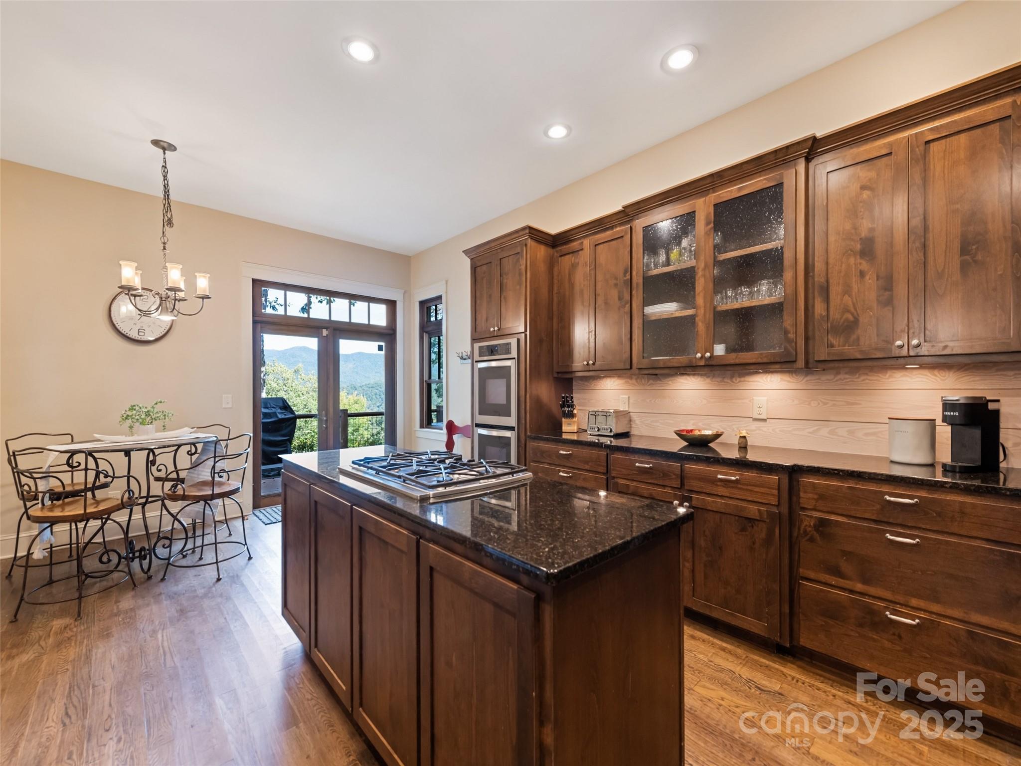 1635 Quest Ridge Sylva, NC 28779 - Photo 16 of 48 a kitchen with stainless steel appliances granite countertop a sink a stove and wooden cabinets