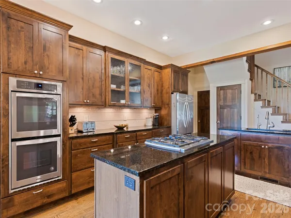 a kitchen with granite countertop stainless steel appliances and wooden cabinets