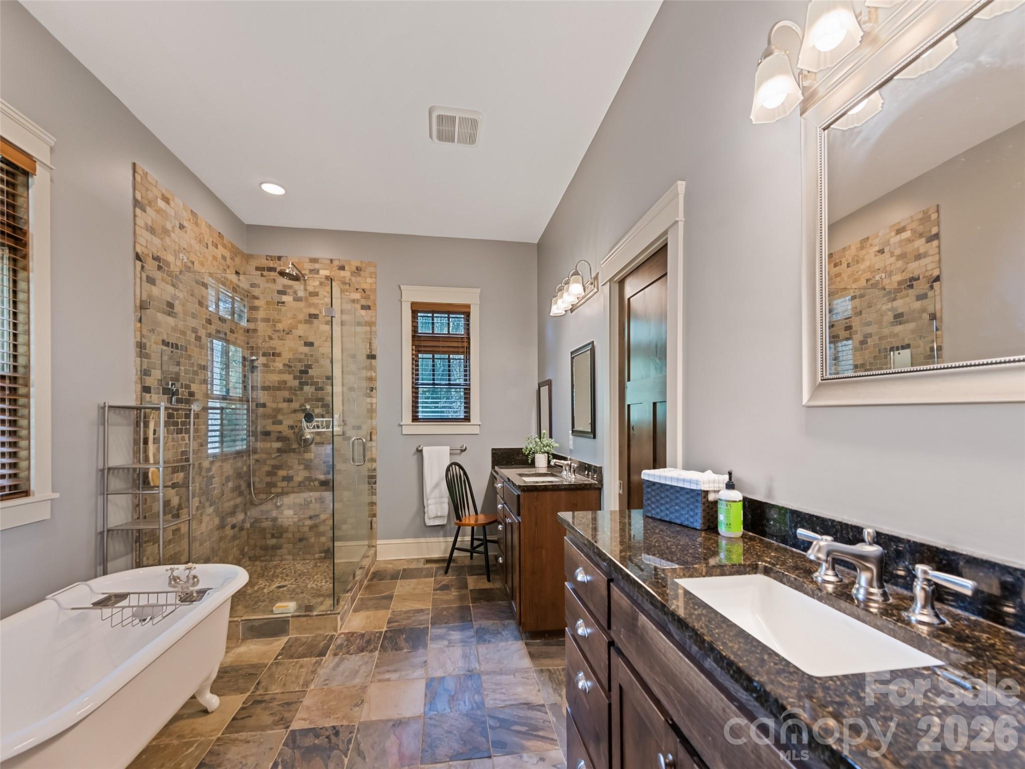 1635 Quest Ridge Sylva, NC 28779 - Photo 22 of 48 a spacious bathroom with a granite countertop sink a toilet a mirror a bathtub and shower