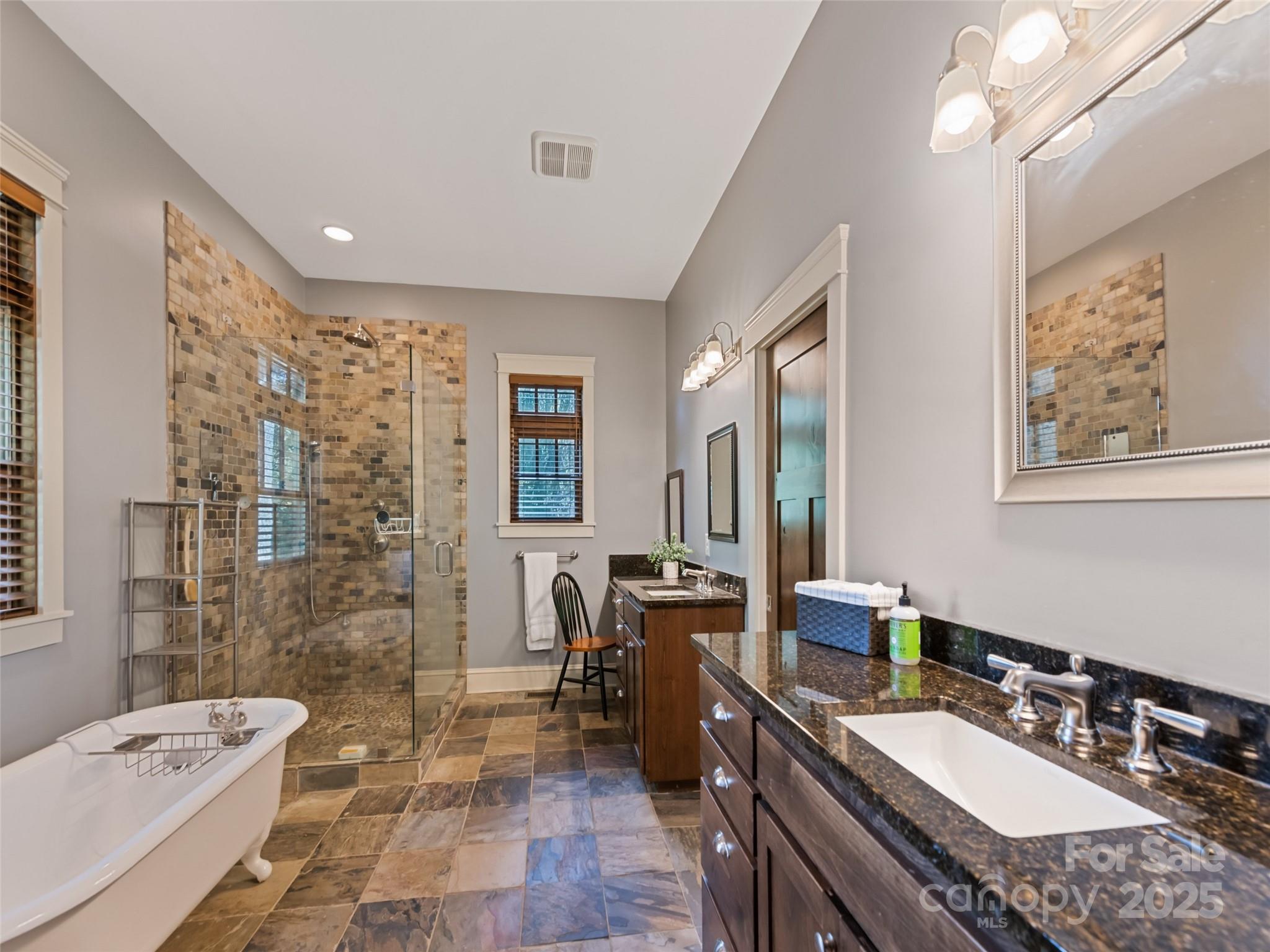 1635 Quest Ridge Sylva, NC 28779 - Photo 23 of 48 a spacious bathroom with a granite countertop double vanity sink a mirror a bathtub and shower