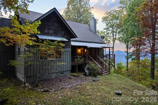 a view of a barn house next to a yard with large trees
