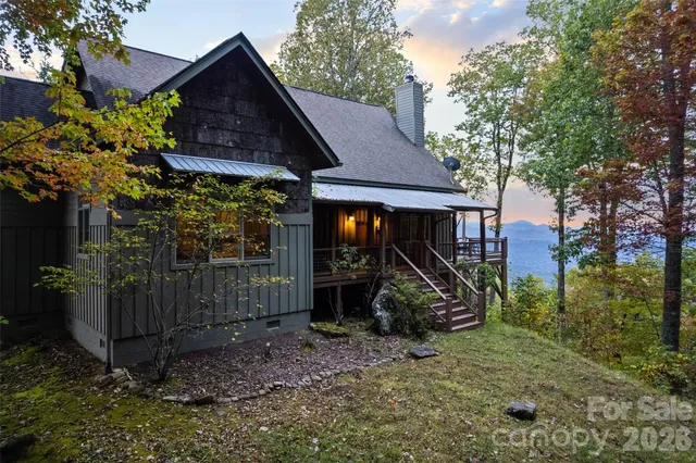 a view of a barn house next to a yard with large trees