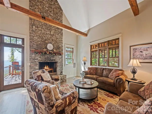 a living room with furniture a fireplace and a large window