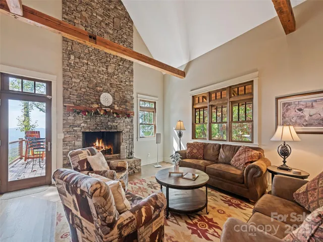 a living room with furniture a fireplace and a large window