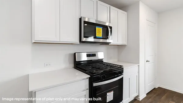 a kitchen with white cabinets and black appliances