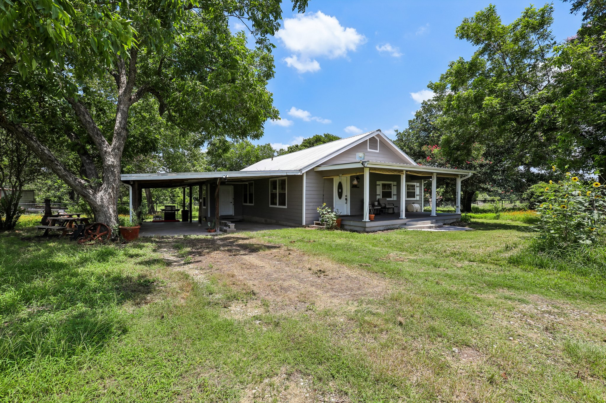 2089 Farm To Market Road 1704 Elgin, TX 78621 - Photo 3 of 31 A welcoming front porch and carport offer rustic charm to this serene country home.