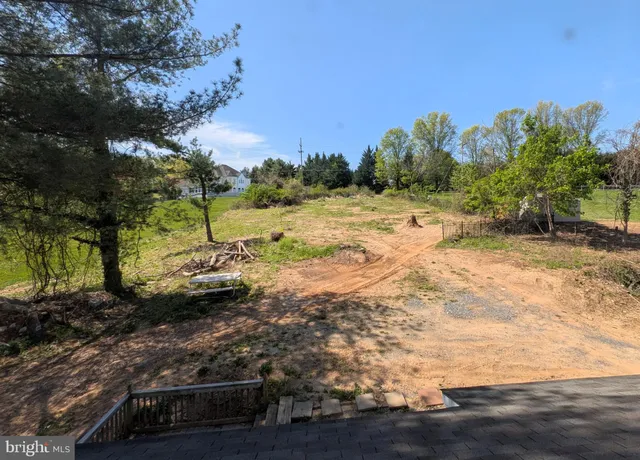 a view of a yard with wooden fence