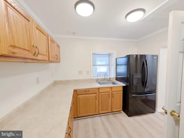 a kitchen with a refrigerator sink and cabinets
