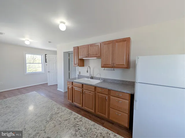 a kitchen with stainless steel appliances granite countertop a refrigerator sink and cabinets