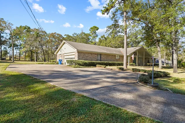 a view of a house with backyard and trees