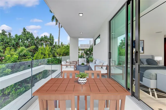 a view of a patio with table and chairs potted plants with floor to ceiling window and potted plants