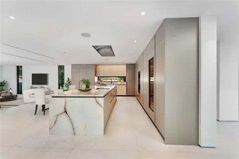 a living room with furniture a flat screen tv and kitchen view