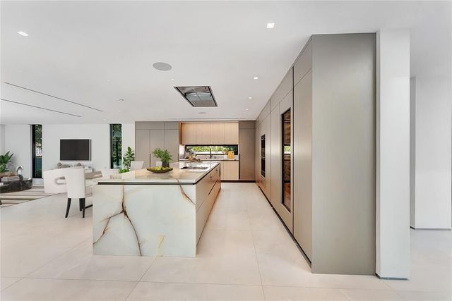 a living room with furniture a flat screen tv and kitchen view