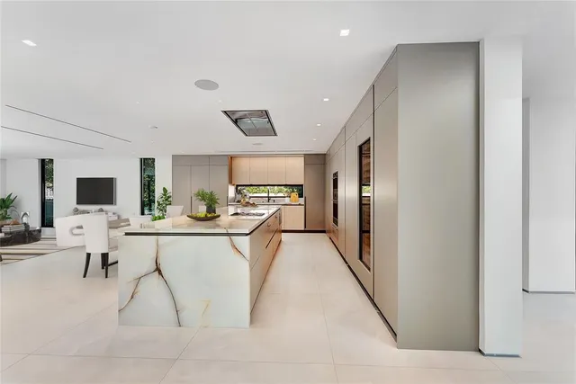 a living room with furniture a flat screen tv and kitchen view