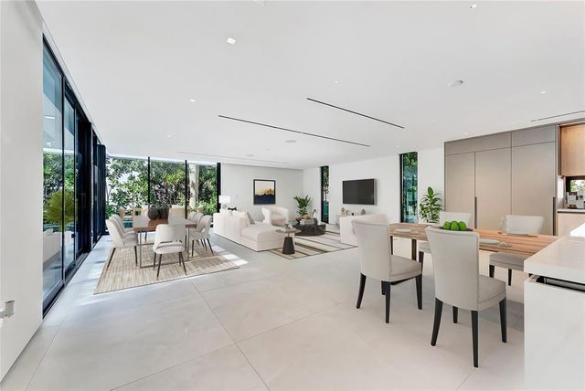 a kitchen with stainless steel appliances kitchen island granite countertop a sink and white cabinets