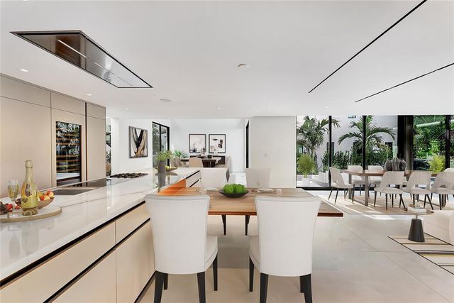 a view of a white house with a yard and potted plants