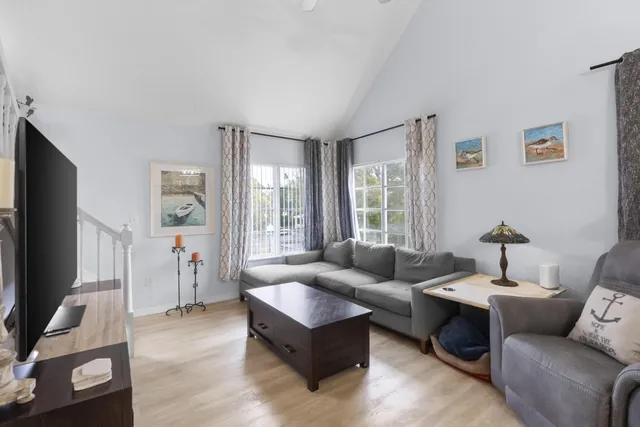 a living room with furniture flat screen tv and a window