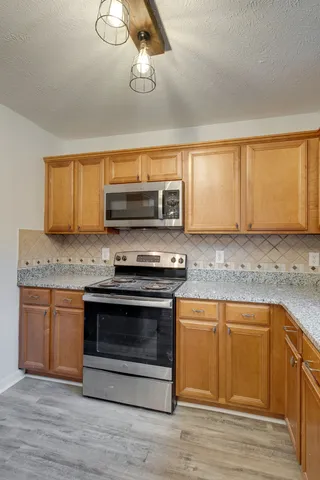 a kitchen with granite countertop a stove and a sink