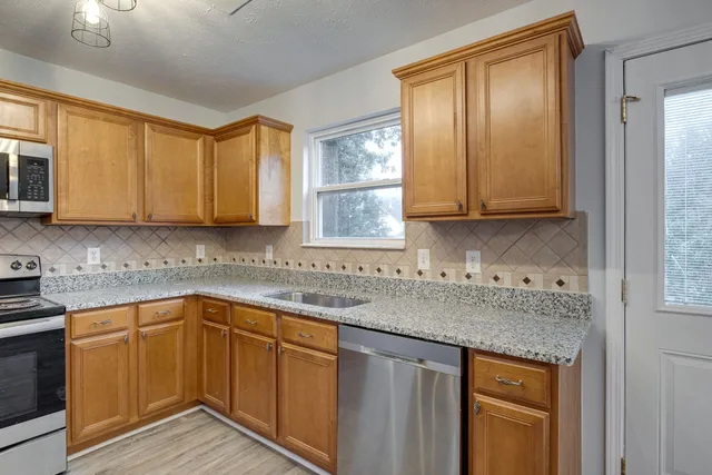 a kitchen with stainless steel appliances granite countertop a sink stove and cabinets