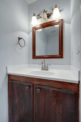 a bathroom with a sink vanity and a mirror