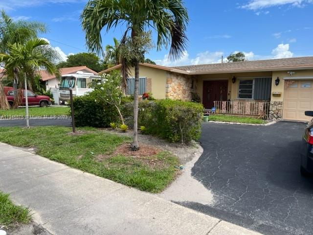 Kendall Green Pompano Beach, FL 33060 - Photo 17 of 24 a front view of house with yard and green space