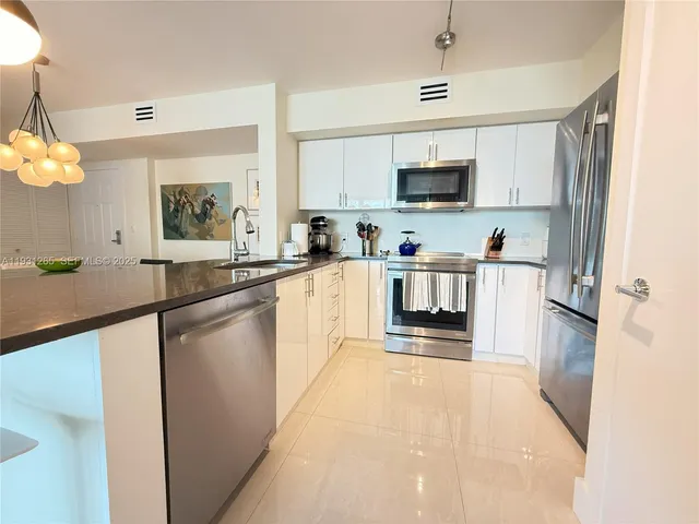 a kitchen with stainless steel appliances a sink stove and refrigerator