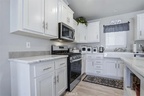 a kitchen with white cabinets and refrigerator