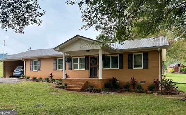 a front view of a house with a garden and plants