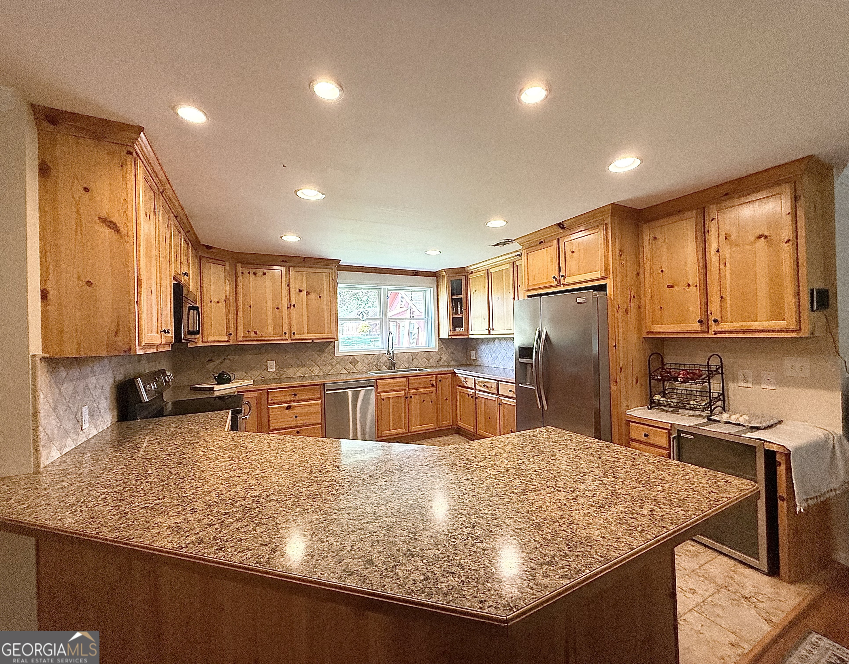 1191 Aderhold Rogers Road Commerce, GA 30530 - Photo 19 of 33 a kitchen with stainless steel appliances granite countertop sink refrigerator and microwave