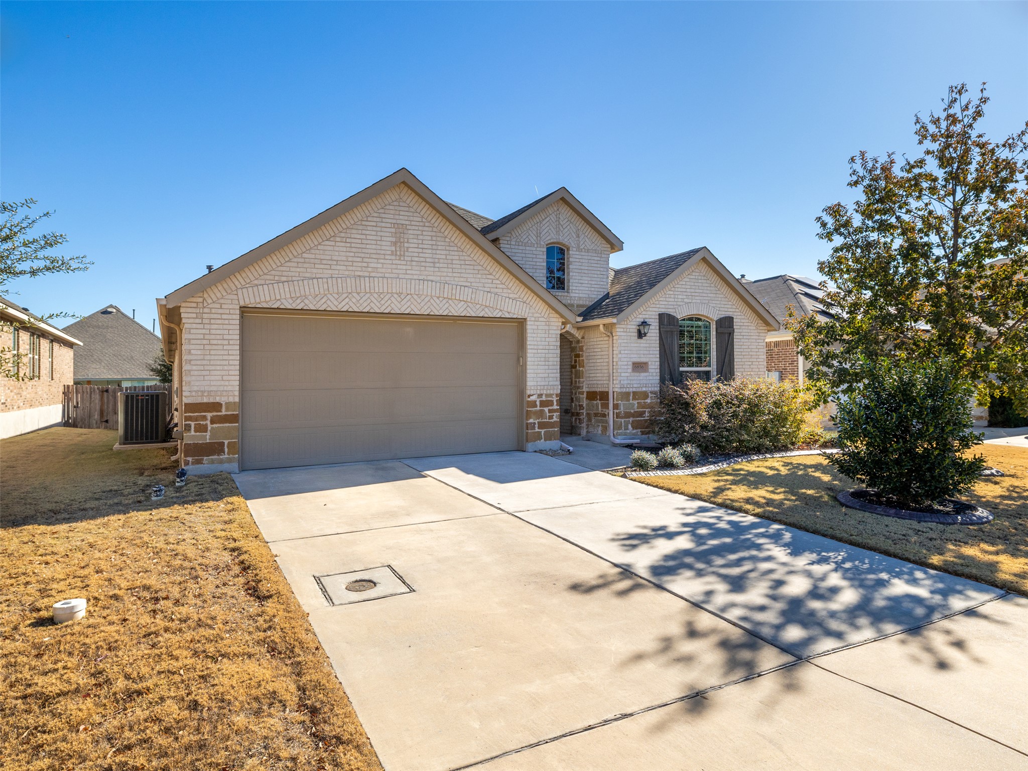 6856 Catania Loop Round Rock, TX 78665 - Photo 2 of 30 Traditional-style home with concrete driveway, a garage, brick siding, and stone siding