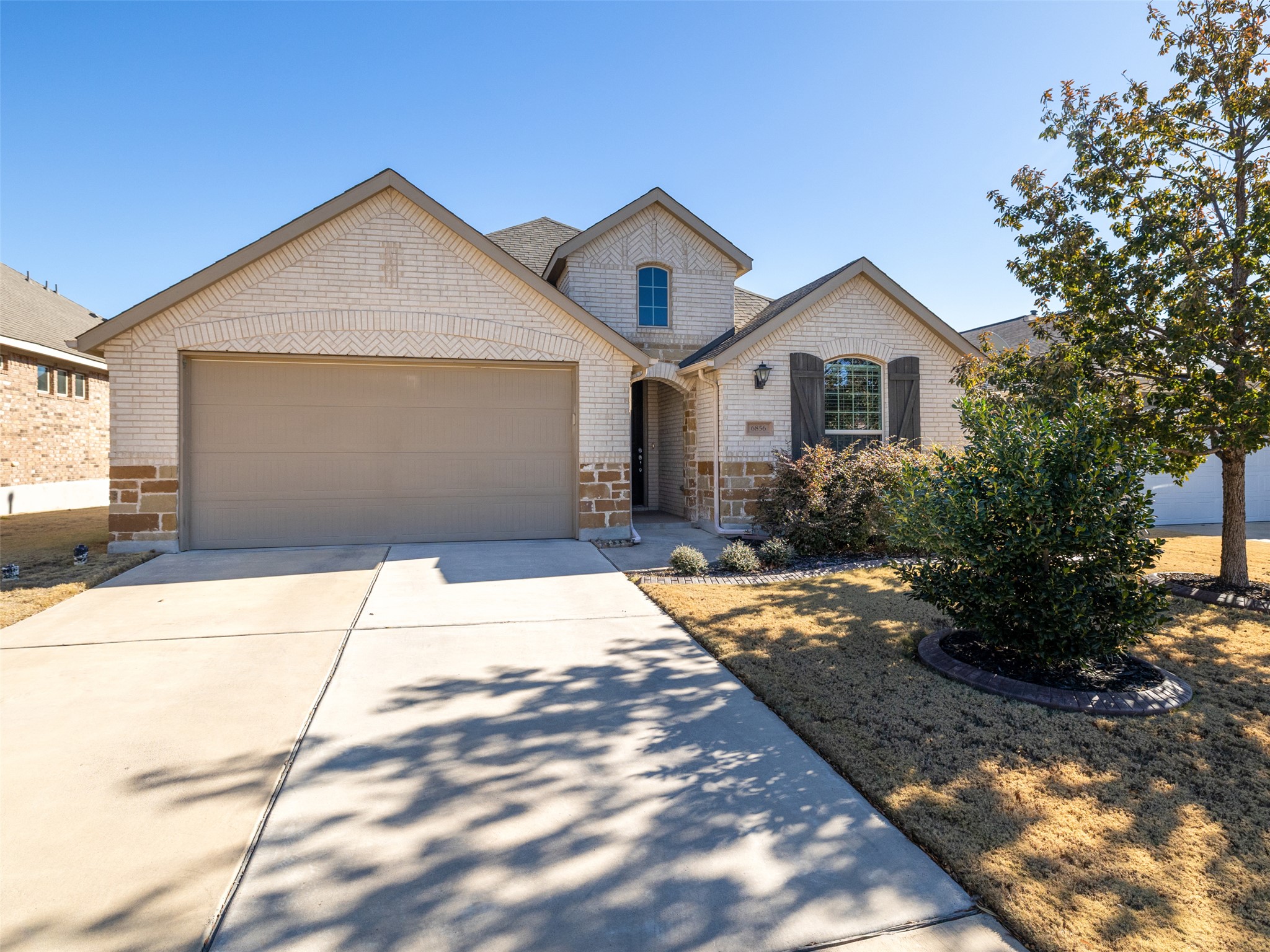 6856 Catania Loop Round Rock, TX 78665 - Photo 3 of 30 View of front of house with a garage, stone siding, and driveway