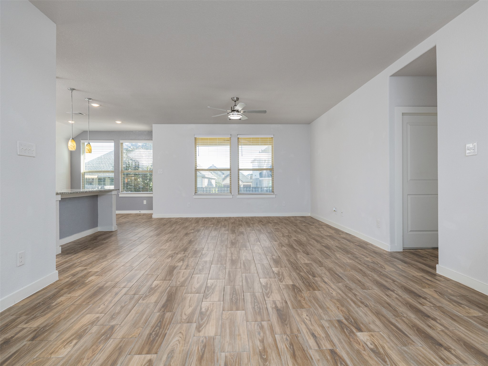 6856 Catania Loop Round Rock, TX 78665 - Photo 4 of 30 Unfurnished living room with light wood-style floors and ceiling fan