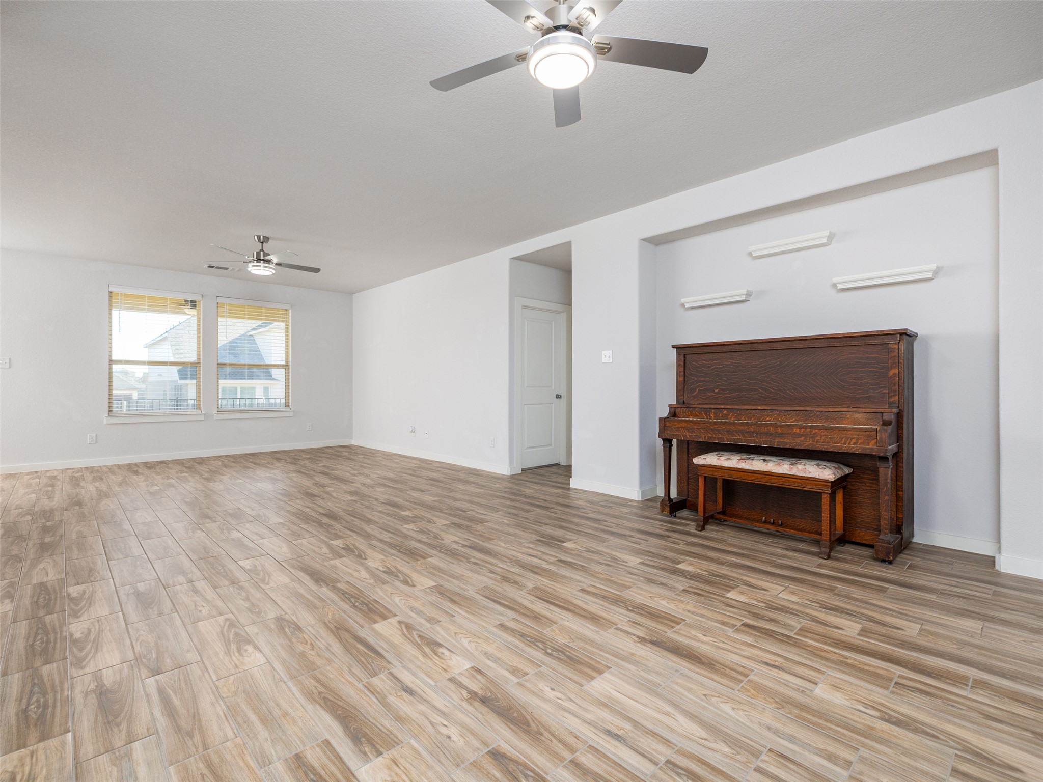 6856 Catania Loop Round Rock, TX 78665 - Photo 7 of 30 Unfurnished living room featuring ceiling fan and wood tiled floors