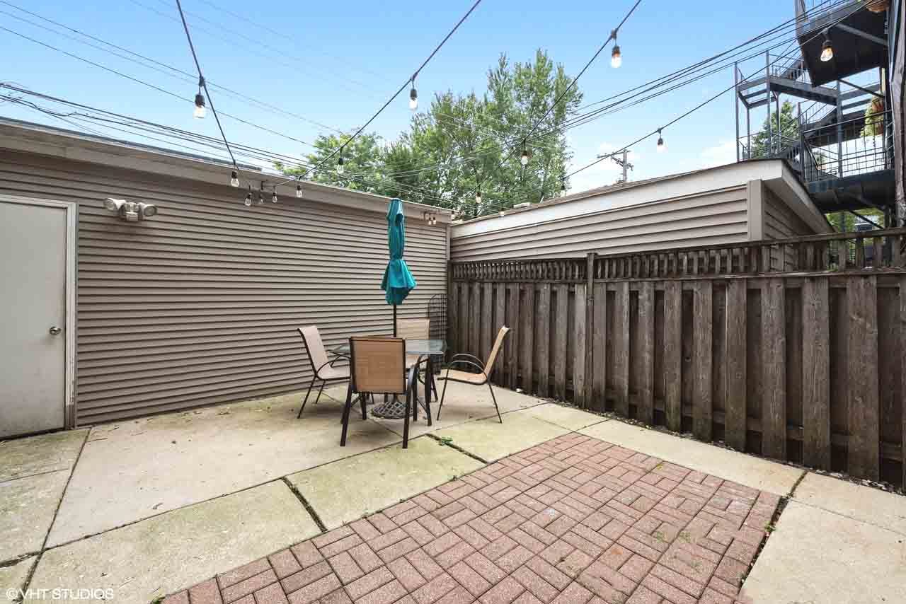 2938 North Damen Avenue, Unit 3 Chicago, IL 60618 - Photo 20 of 22 a backyard of a house with table and chairs
