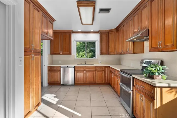 a kitchen with stainless steel appliances granite countertop a stove a sink and a microwave
