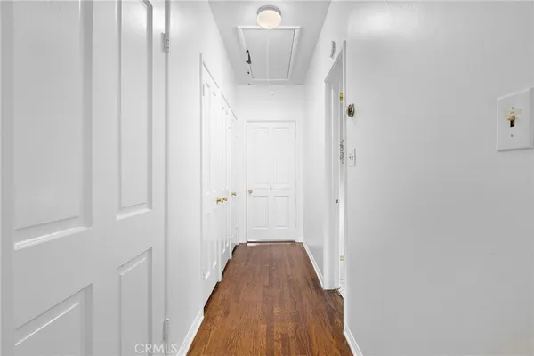 a view of a hallway with wooden floor and entryway