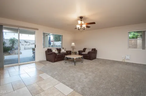 a living room with furniture a flat screen tv and a window