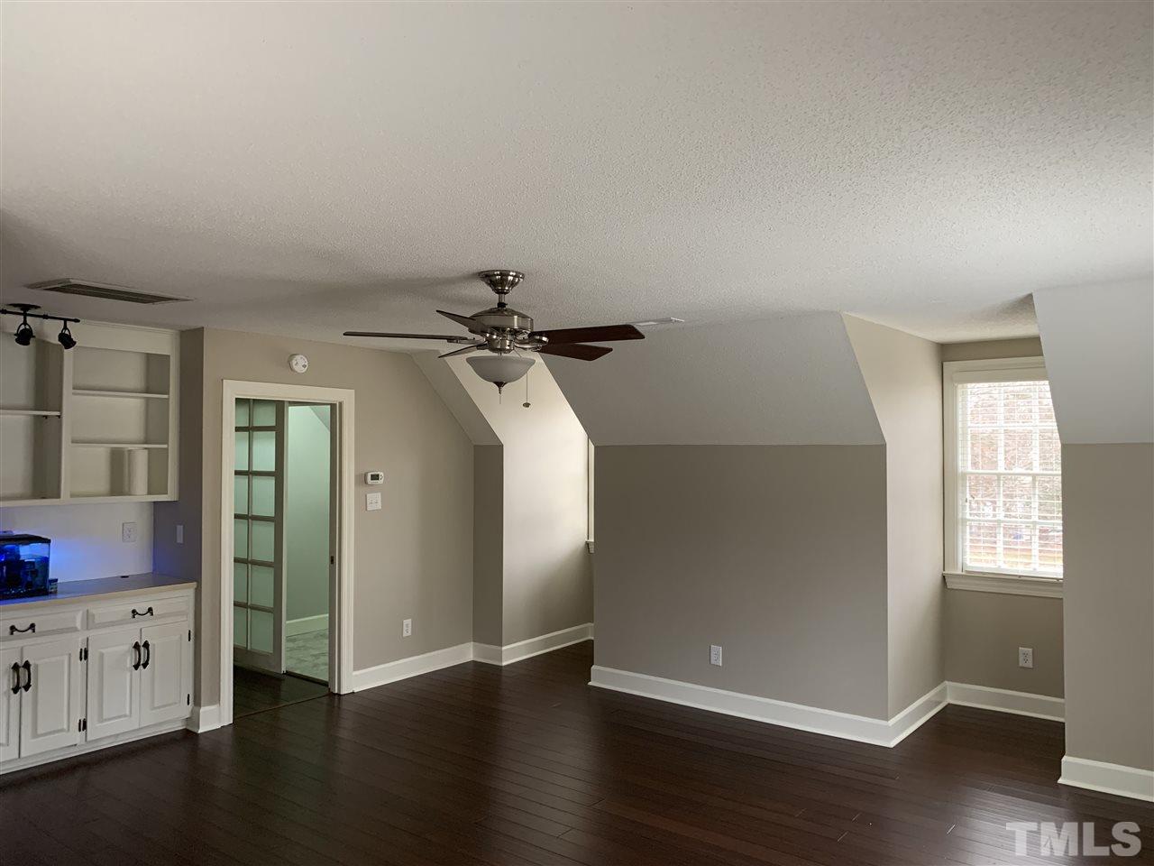 8800 Audley Circle Raleigh, NC 27615 - Photo 9 of 27 an empty room with wooden floor cabinet and windows